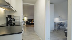 A modern kitchen with a built-in stove and a dining area with a table and chairs. - Scandinavian Charm in Aalborg (Aalborg)