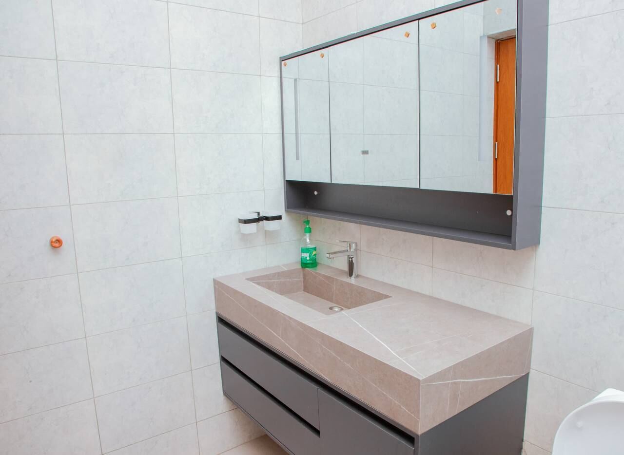 A bathroom with a sink, mirror, and a cabinet.