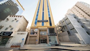 Egy magas épület, amelyen feltűnő tábla hirdeti a „Borg Al Sumou Travel & Tourism” nevű utazási iroda és turisztikai szolgáltatót.