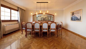 A dining room with a wooden herringbone floor, a large dining table surrounded by six chairs, a chandelier, and a large mirror above the table. - Kennah Lascaic | 3BR Near Korba & Metro, Heliopolis (Cairo)