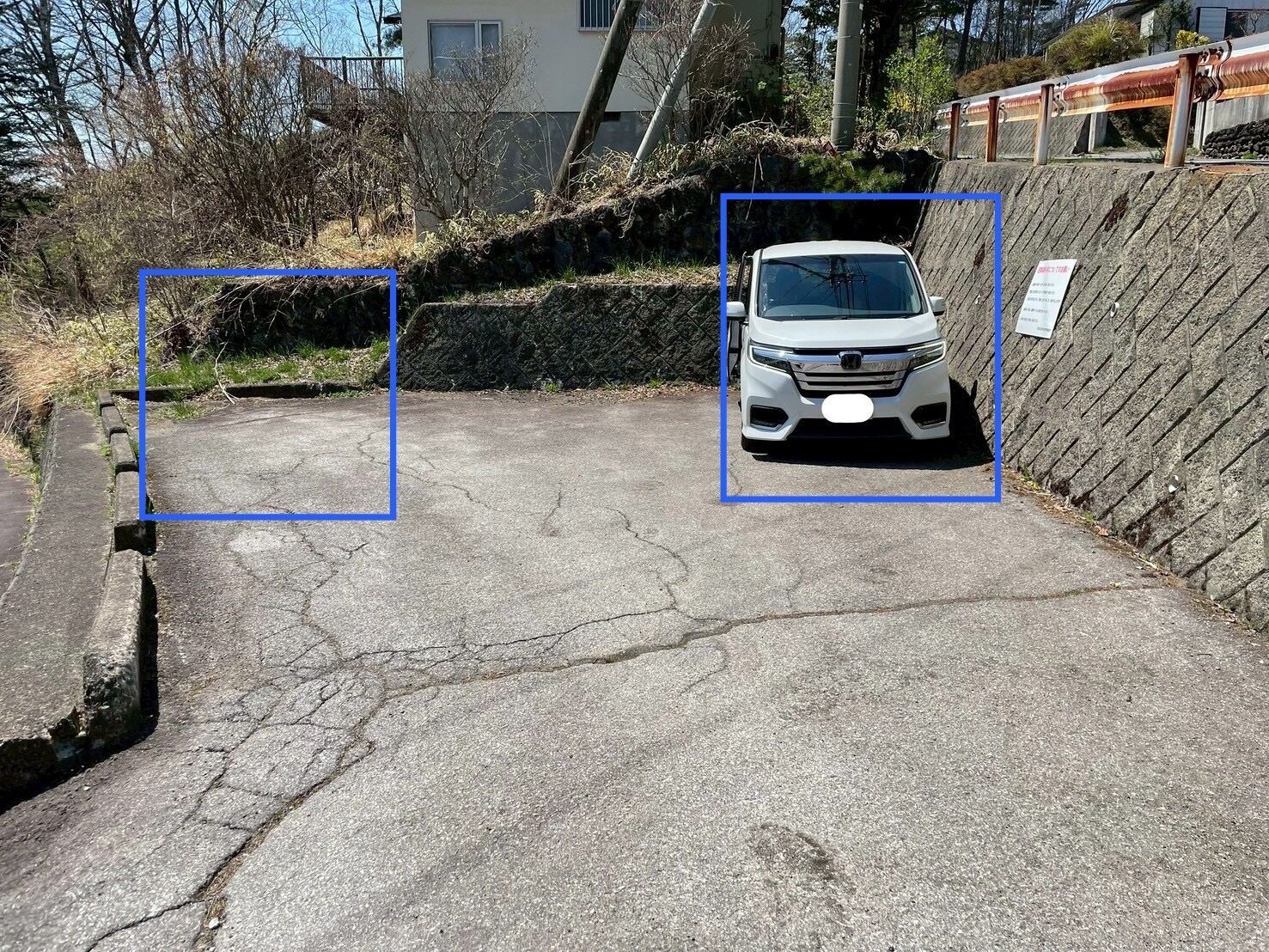 A parking area with a white car parked in the center.