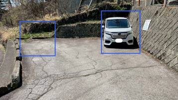 A parking area with a white car parked in the center.