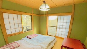 A room with a bed, a small table, and sliding doors.