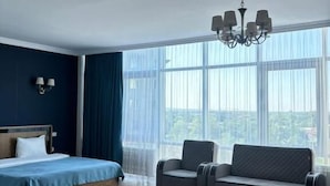 Una habitación de hotel moderna con una cama grande, un sofá y una araña.