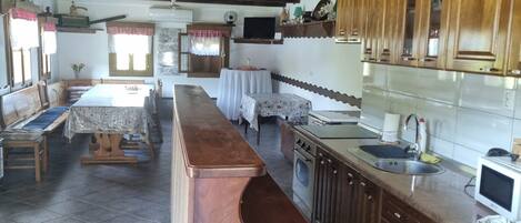 A rustic kitchen with wooden cabinets, a long counter, and a built-in oven.
