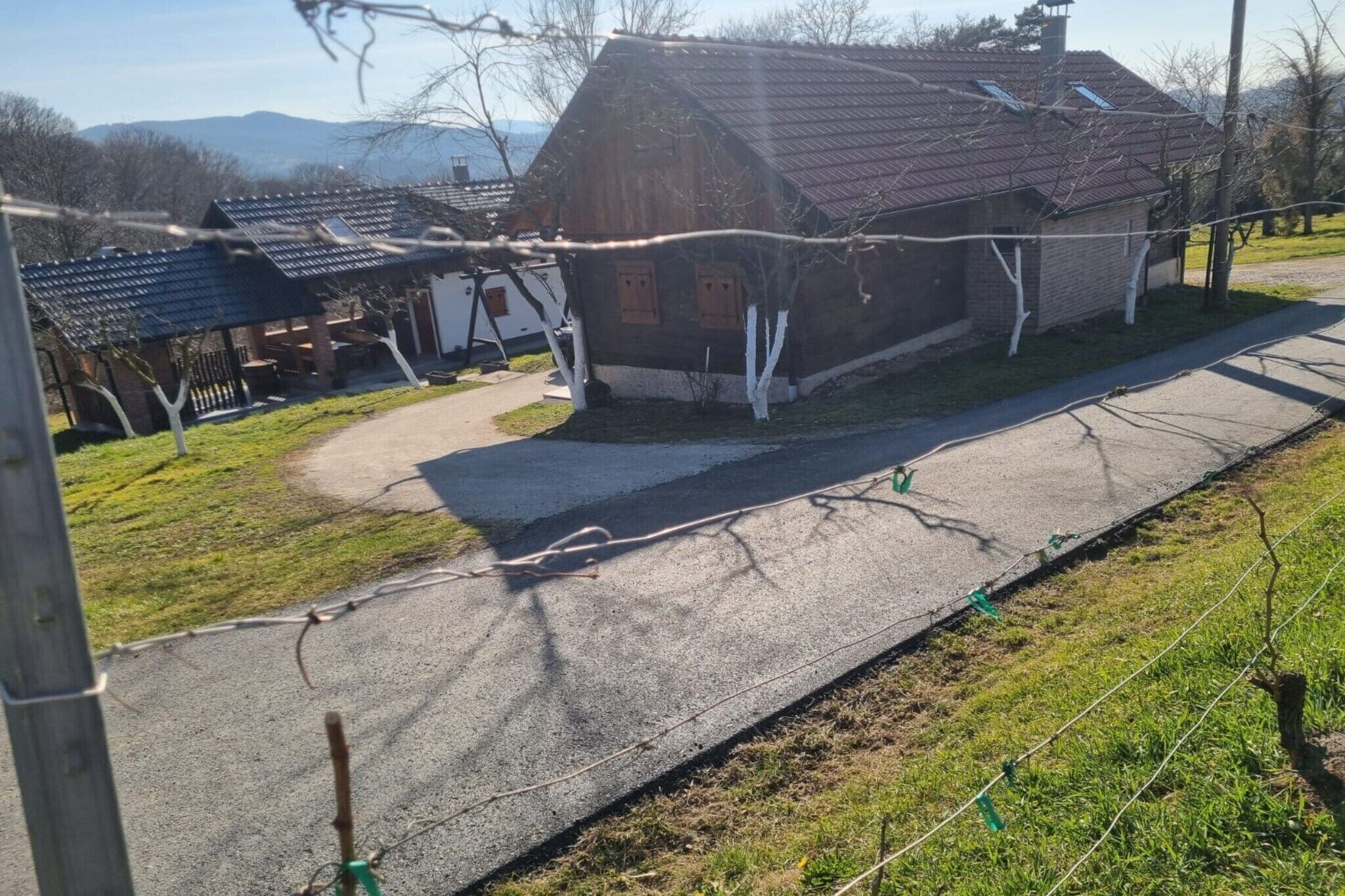 Ein ländliches Haus mit Satteldach, befestigter Auffahrt und einem eingezäunten Garten.