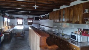 Une cuisine avec des meubles de rangement en bois, un îlot central, un four à micro-ondes et un évier.