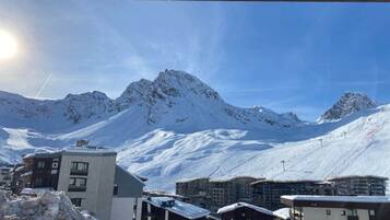 Un pueblo cubierto de nieve en la montaña, con edificios modernos y un cielo despejado.