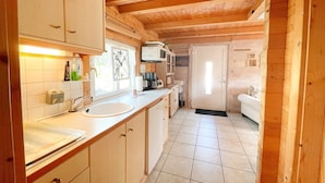 A compact kitchen with a sink, cabinets, and a coffee machine.