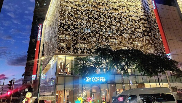 A modern building with a geometric facade and a 'Key Coffee' shop at the ground level.