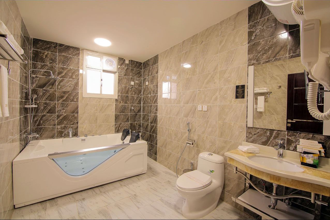 A modern bathroom with a bathtub, toilet, and sink.