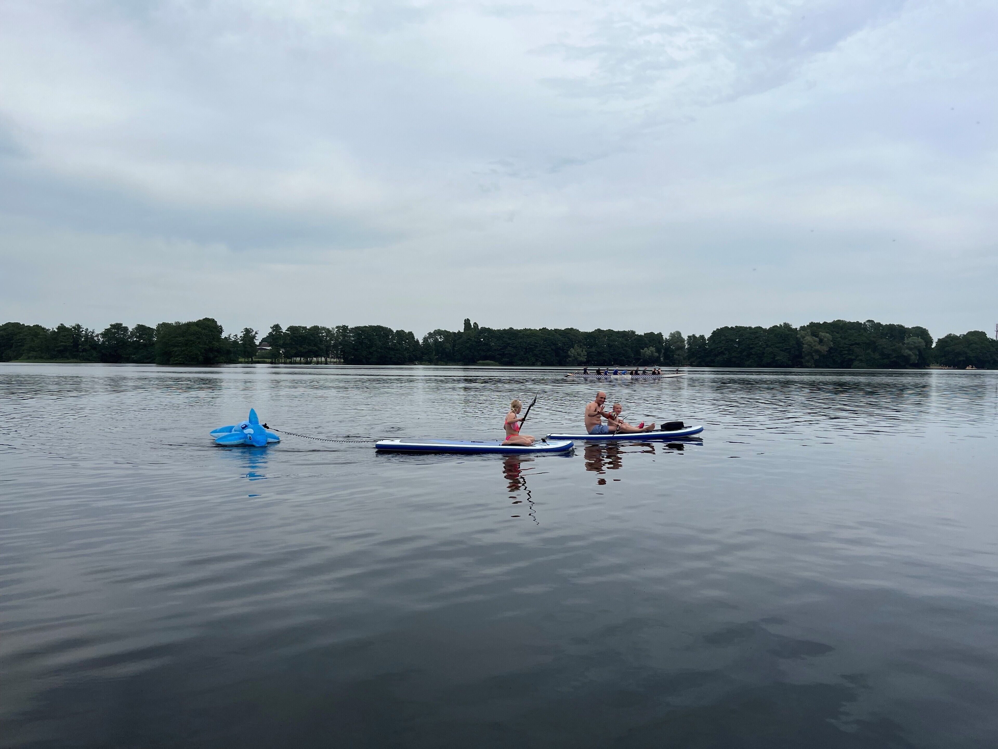 Ein ruhiger See mit Booten und einer entfernten Uferlinie.