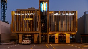 A hotel with a modern facade, featuring illuminated signage in both English and Arabic. - Royal Palace Hotel - Financial District (Riyadh)