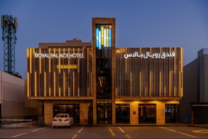 A hotel with a modern facade, featuring illuminated signage in both English and Arabic. - Royal Palace Hotel - Financial District (Riyadh)