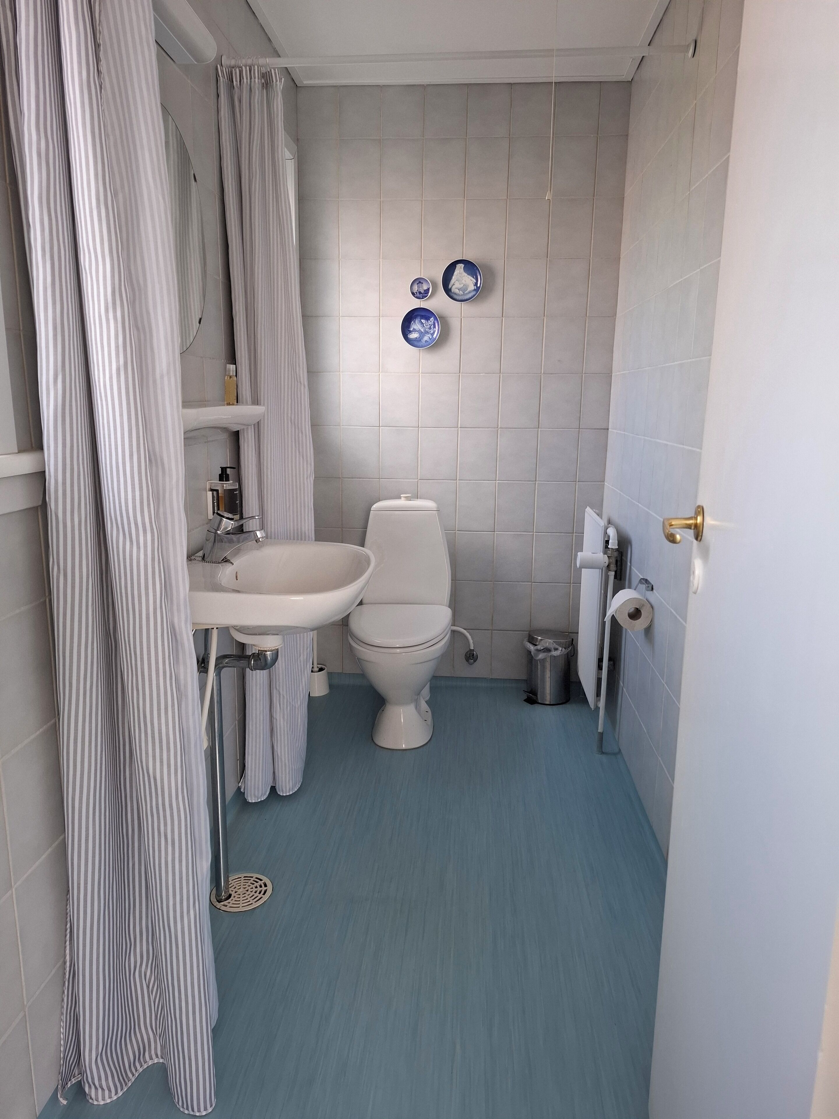 Ein kleines Badezimmer mit Toilette, Waschbecken und Duschvorhang.