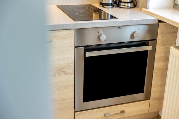 A kitchen with a built-in oven, a stovetop, and a microwave.