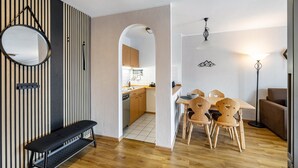 Una cocina moderna con armarios de madera, una mesa de comedor con sillas, un banco y un espejo redondo en la pared.