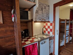 A compact kitchen with a microwave, coffee maker, and a sink. - Cozy studio in Valfréjus, near the slopes (Valfréjus)