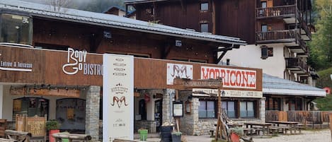 A rustic building with wooden balconies and a sign for a bar and billiard.