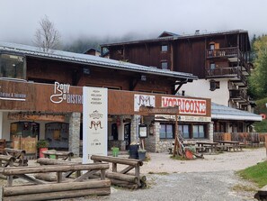 A rustic building with wooden balconies and a sign for a bar and billiard. - Cozy studio in Valfréjus, near the slopes (Valfréjus)