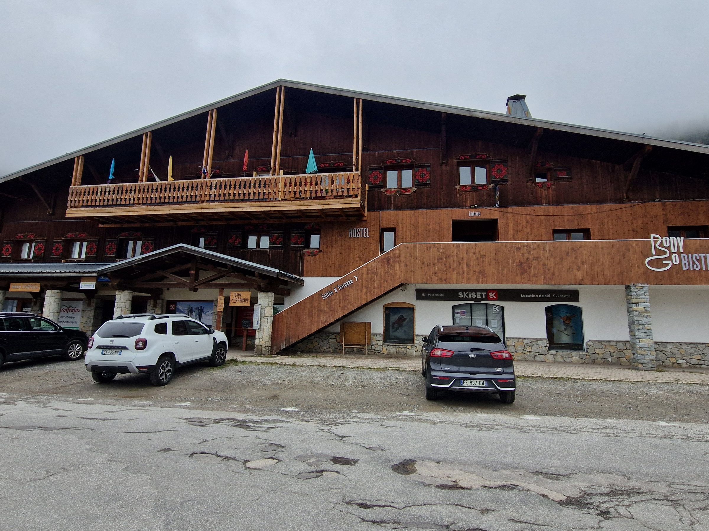 A building with a wooden facade, a balcony, and a sign for 'Body Bistro.'