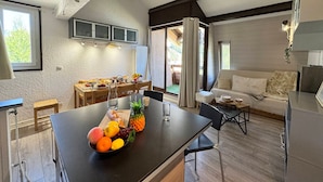A modern kitchen with a central island, wooden dining table, and a cozy seating area with a sofa and chairs. - Apartment at the foot of the slopes in Vars Les Claux, pets allowed (Vars)