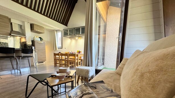 A cozy living room with a large window, a dining area, and a kitchen in the background. - Apartment at the foot of the slopes in Vars Les Claux, pets allowed (Vars)