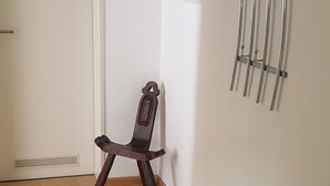A wooden chair in a room with a white door and a radiator on the wall. - Apartment '3' with Shared Terrace, Balcony and Wi-Fi (Weil am Rhein)