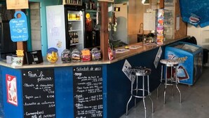 A café counter with a chalkboard menu, a refrigerator, and a blue box of Nestle ice cream. - Family mobile home with terrace in Vendays-Montalivet (Vendays-Montalivet)