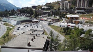 A town with a central road, buildings, and a mountainous backdrop. - Maxi studio 6 pers, central Orcières, near slopes (Orcières Merlette)