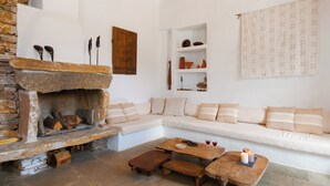 A cozy living room with a stone fireplace, a white sofa, and a wooden coffee table.