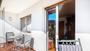 A balcony with a table and chairs, a sliding glass door, and a view of the interior. - Apartment 'Kropp' with Mountain View, Balcony and Wi-Fi (Steinen)