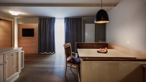 Un comedor moderno con una mesa de madera, sillas y una lámpara colgante.
