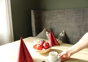 Une table avec un bol de pommes, une tasse de café et une serviette.