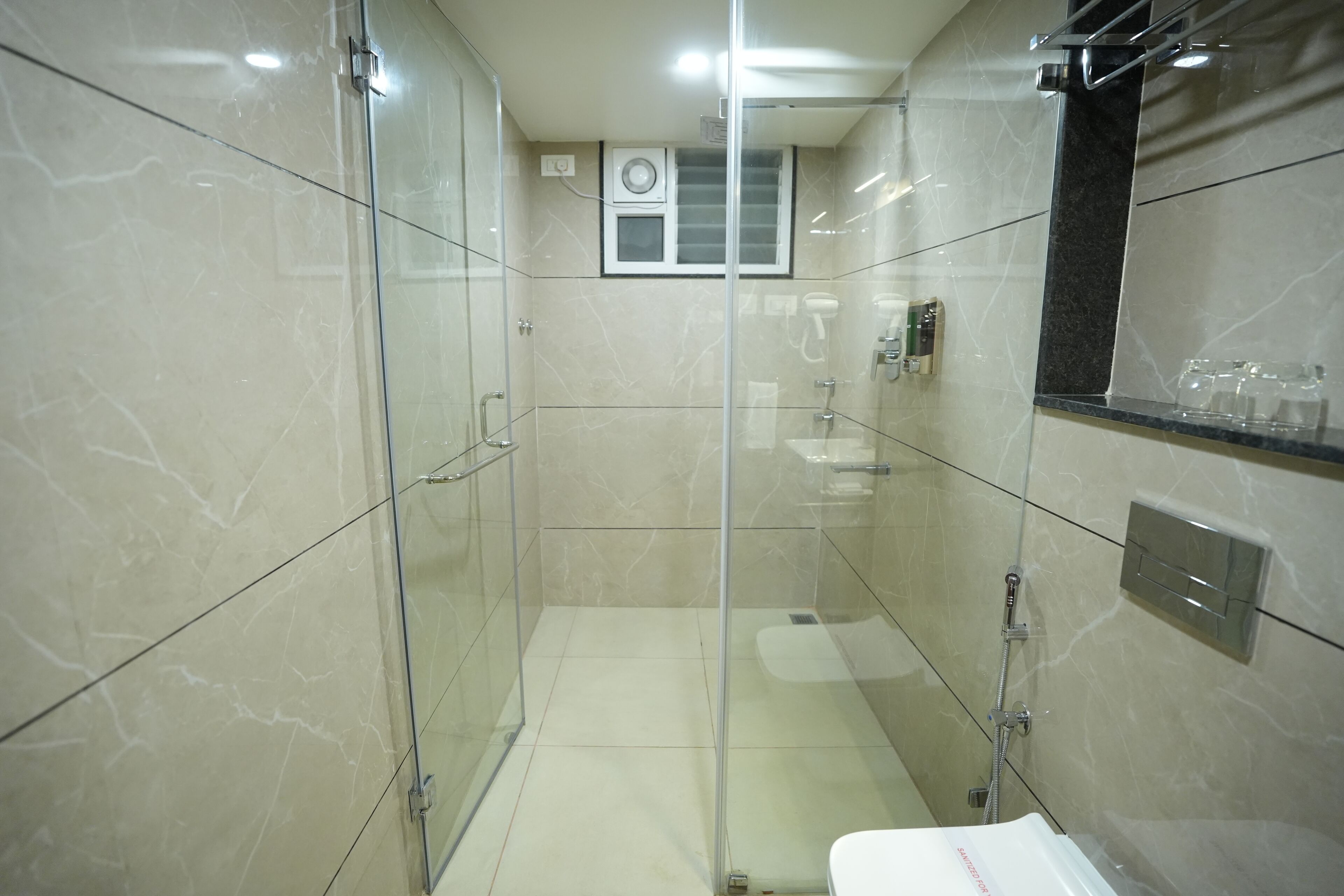 Een moderne badkamer met een douchecabine van glas, een toilet en een wastafel.
