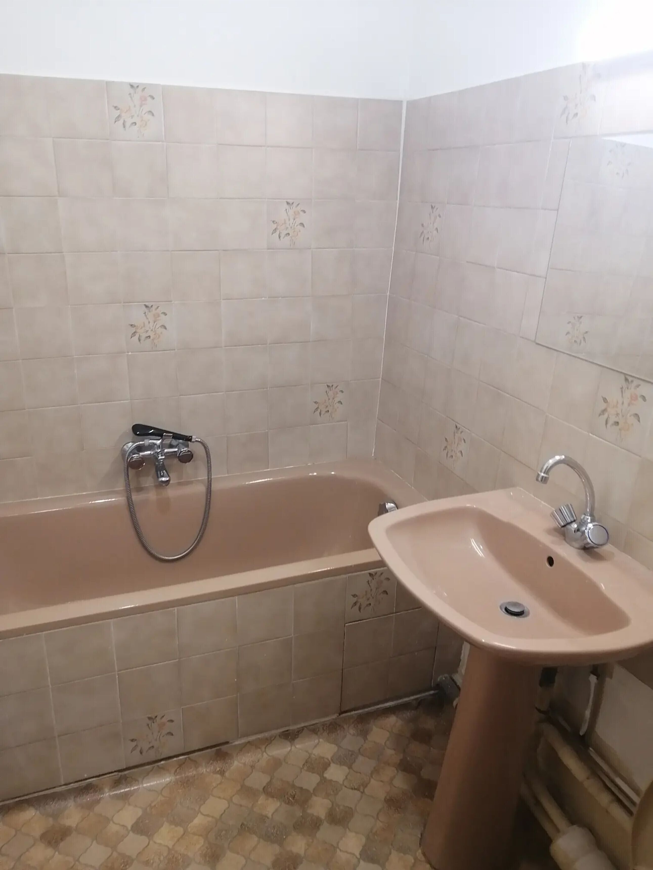 Un baño con bañera, lavamanos y paredes de azulejos.
