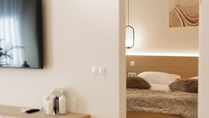 A modern bedroom with a bed, bedside table, and a hanging light fixture. - Nest Inn Boucle Apartment (Baia Mare)