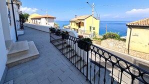 A coastal residential area with a paved walkway, a metal railing, and a clear view of the sea. - Al 211 Rooms (Pizzo)