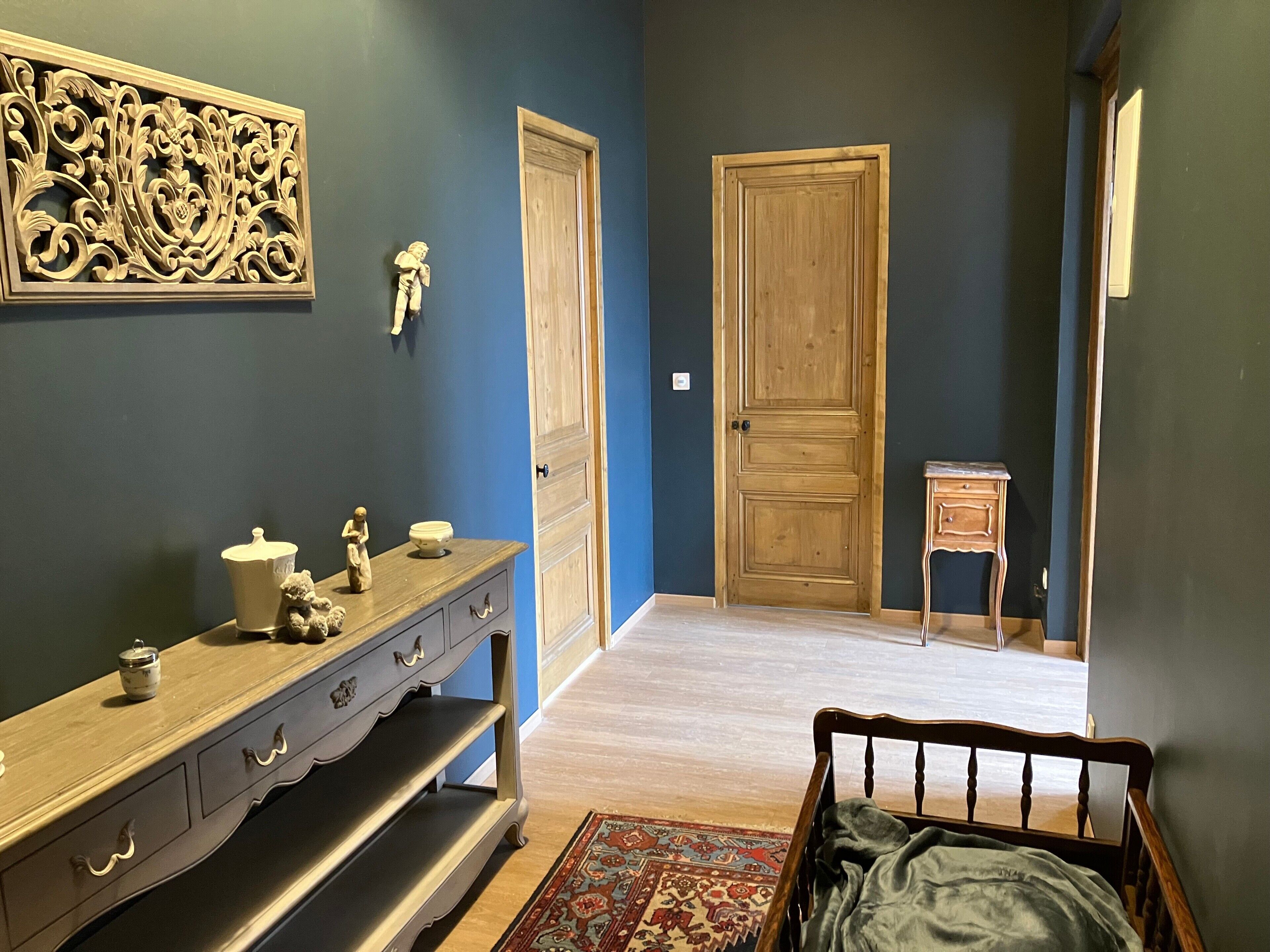 Een slaapkamer met een bed, een kaptafel en een deur naar een andere kamer.