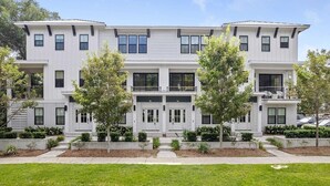 A modern two-story building with a symmetrical facade, large windows, and a central entrance.