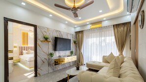 A modern living room with a sofa, TV, and a ceiling fan.