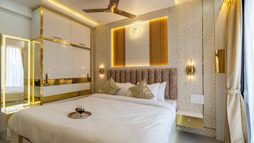Une chambre d’hôtel moderne avec un grand lit, un ventilateur de plafond et un panneau décoratif mural.