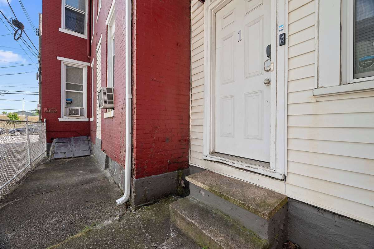 A red brick building with a white door and a small porch.