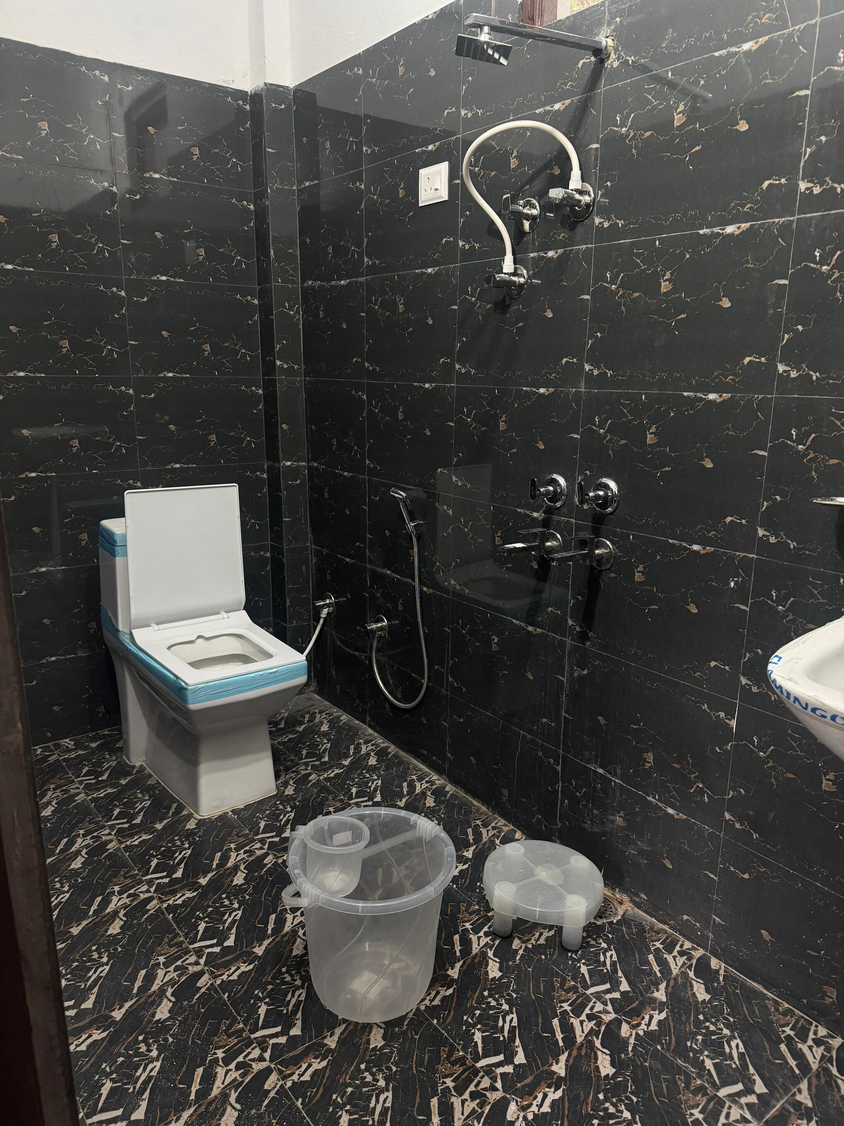 A bathroom with a toilet, shower, and sink.