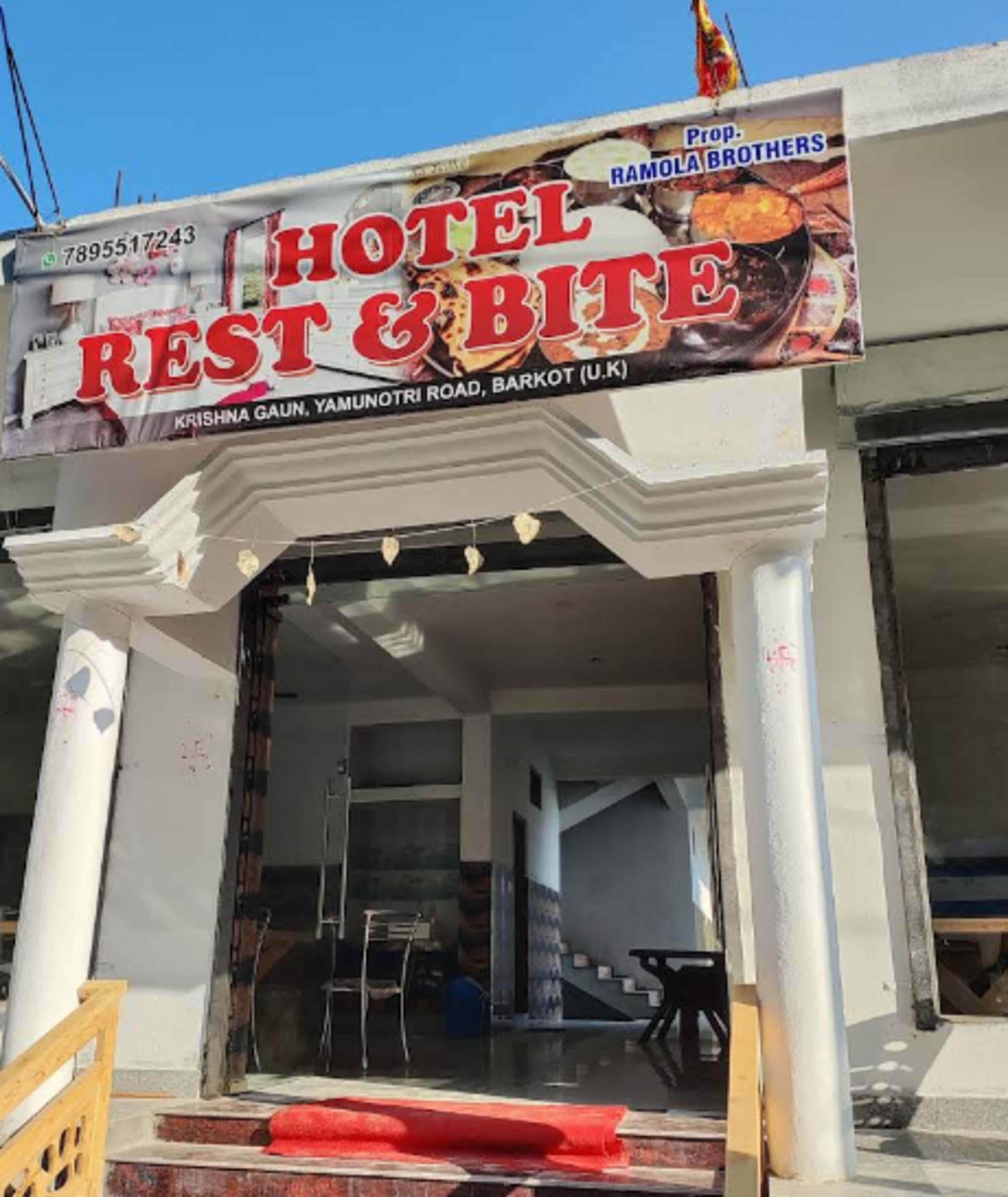 Un hotel llamado "Hotel Rest & Bite" con un cartel publicitario de Ramola Brothers.
