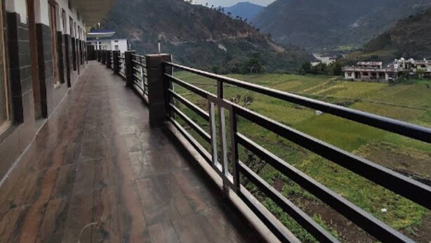 A covered corridor with a view of a mountainous landscape. - Hotel Rest and Bite (Rajgarhi)