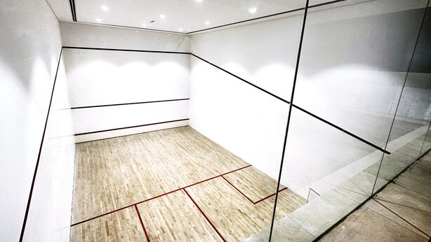 A modern, empty room with a wooden floor, white walls, and glass partitions. - Stylish 1BR Dubai Marina w Pool and Gym (Dubai)