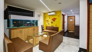 Un vestíbulo moderno con un gran acuario, mobiliario de madera y una pared de acento amarilla.