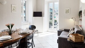 Eine moderne Wohnung mit Essbereich, Wohnzimmer und Balkon mit Blick auf die Stadt.