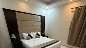 A modern bedroom with a large bed, a headboard, a nightstand, and a lamp. - Osus G (Yanbu)